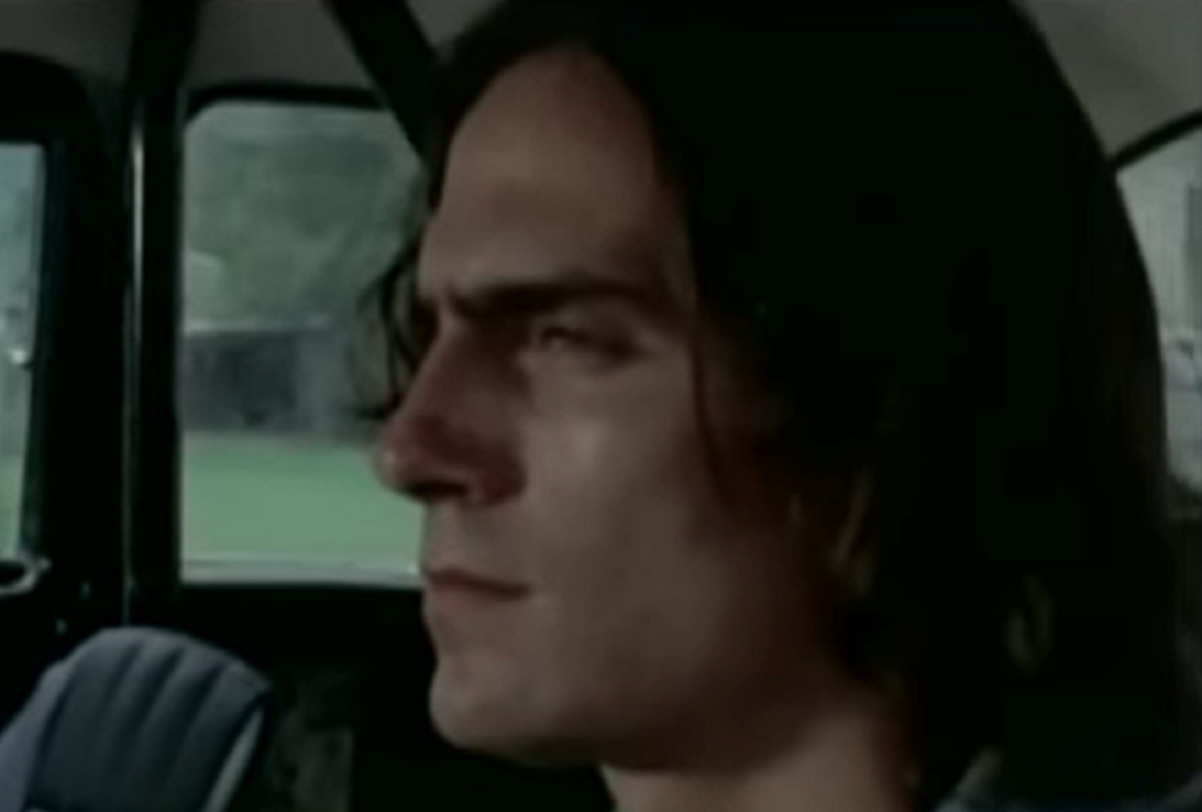Screenshot of James Taylor with long hair driving a car - from Two-Lane Blacktop (1971)