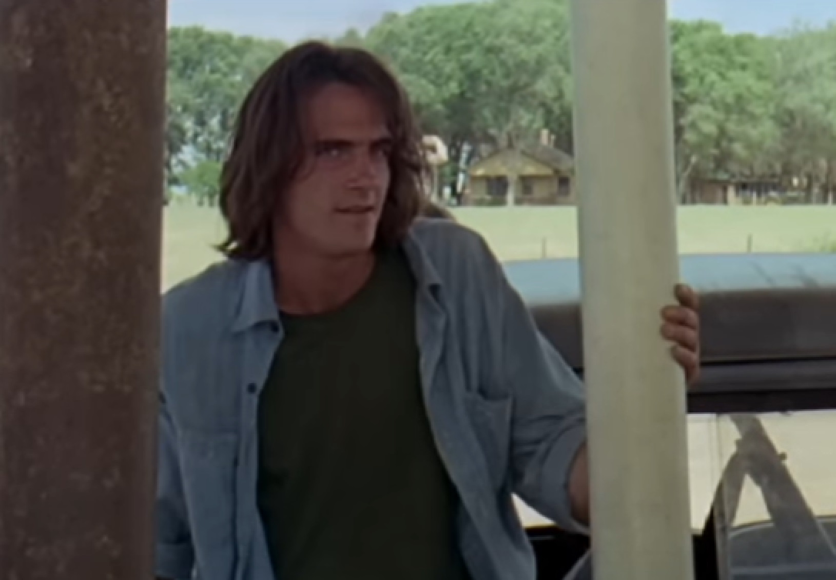 Screenshot of James Taylor with long hair and blue shirt - from Two-Lane Blacktop (1971)