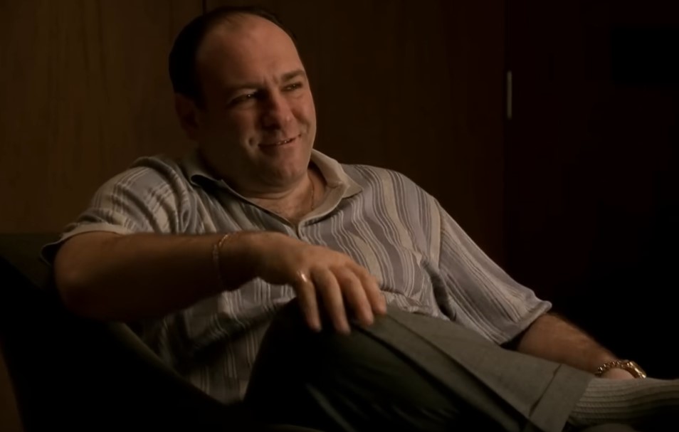James Gandolfini as Tony Soprano in gray t-shirt sitting on a chair