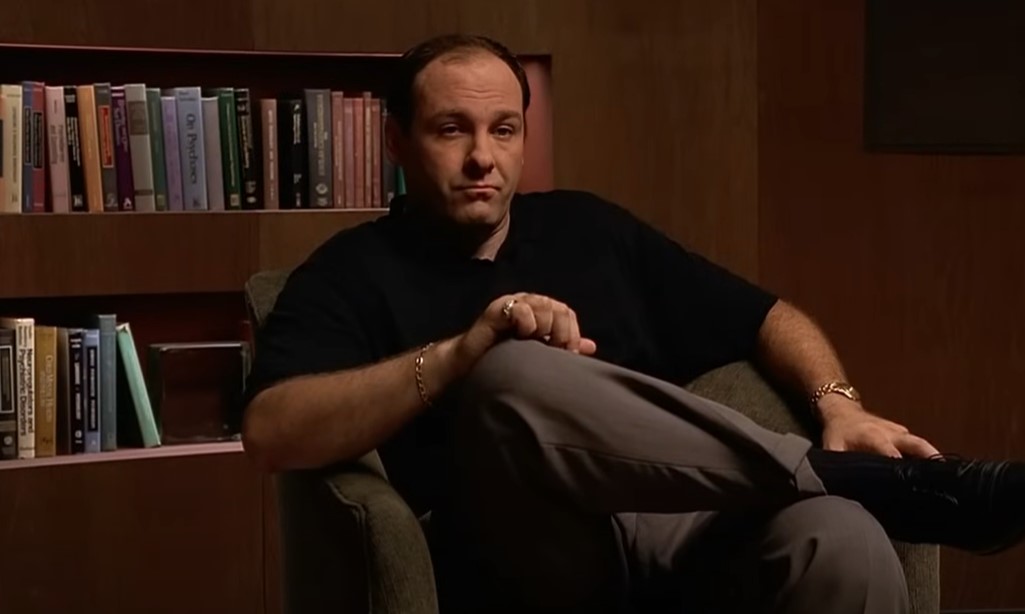 James Gandolfini as Tony Soprano in black t-shirt sitting on a chair