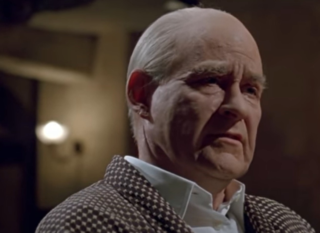 Screenshot of Cole Porter (Kevin Kline) seating and looking at side  from - De-Lovely (2004)