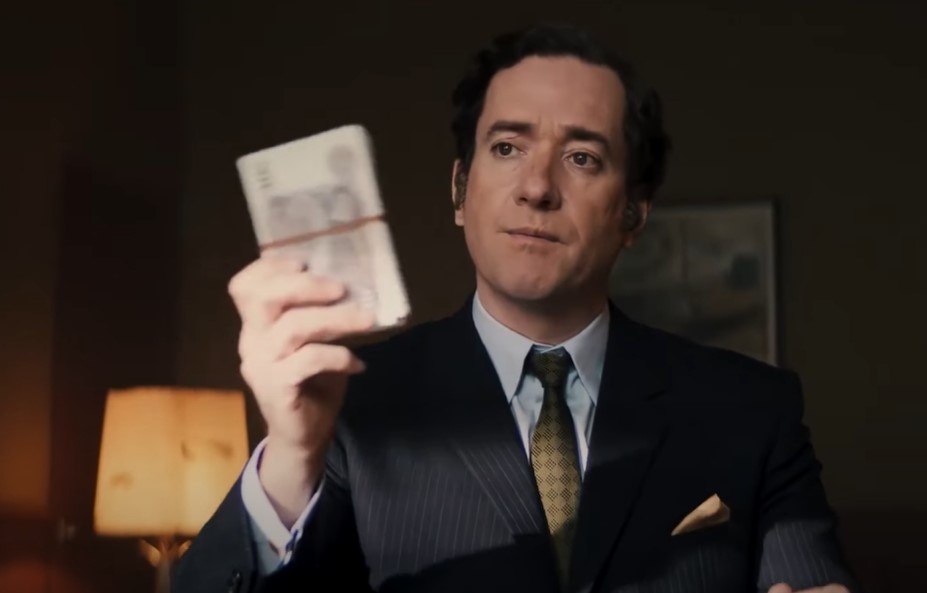Matthew Macfadyen as John Stonehouse holding money