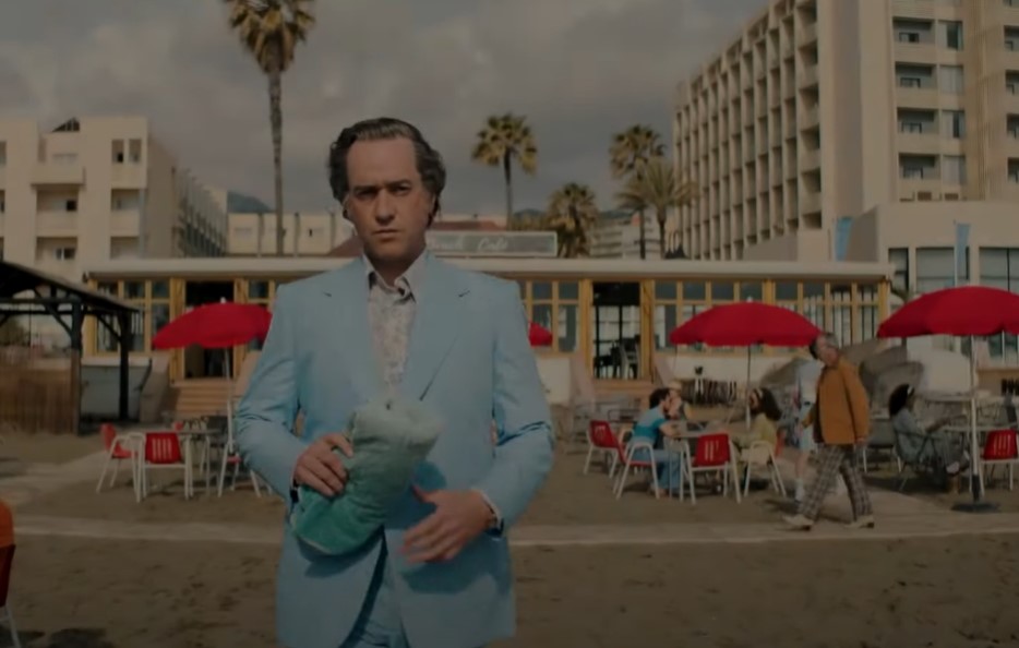 Matthew Macfadyen as John Stonehouse in blue suit at beach