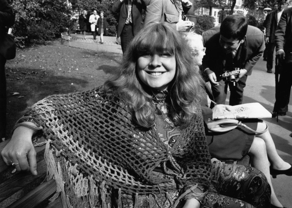 British folk singer-songwriter Sandy Denny sitting in a park