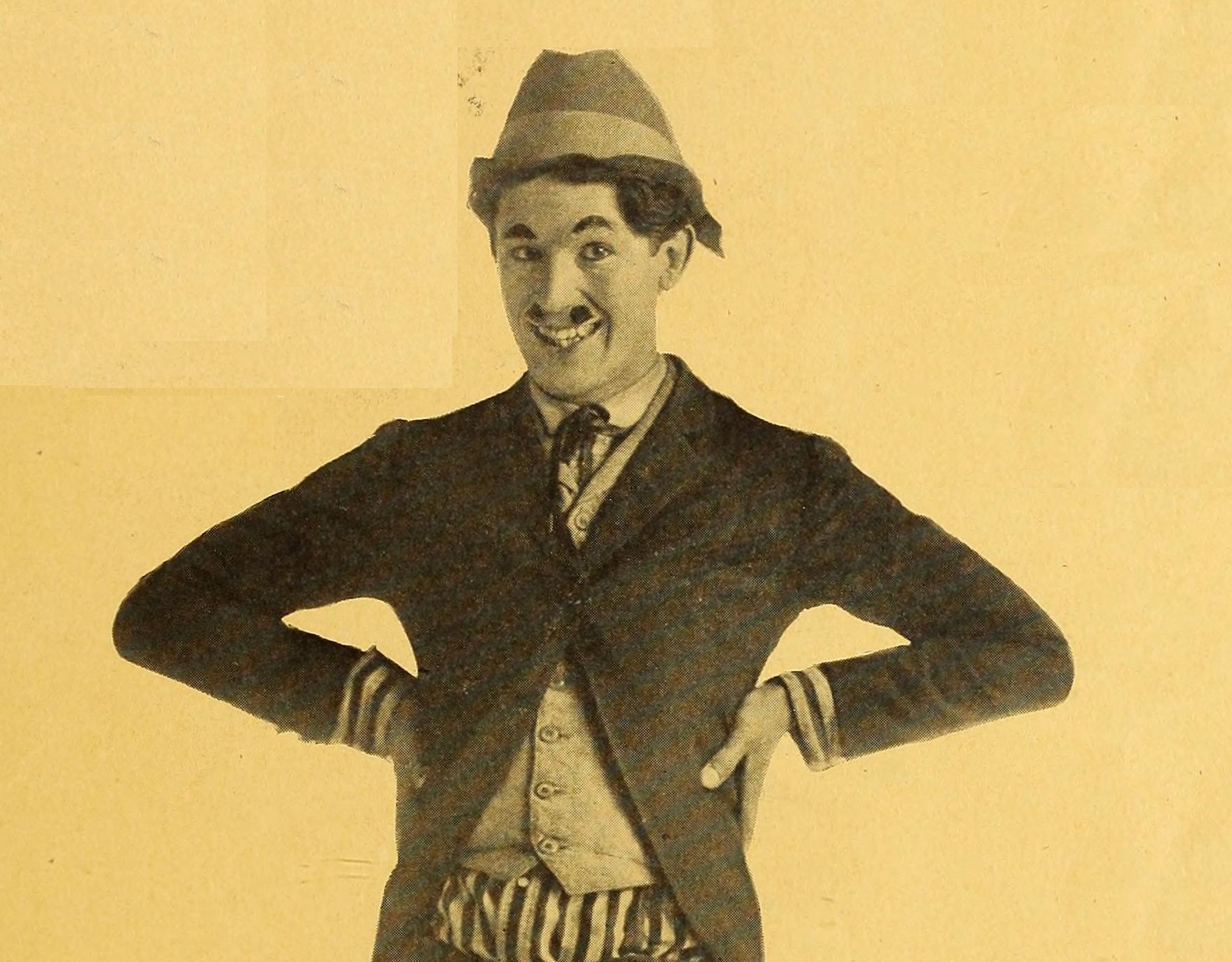 Photo of  Harold Lloyd early in his career in gunny costume and hat smiling- 1917