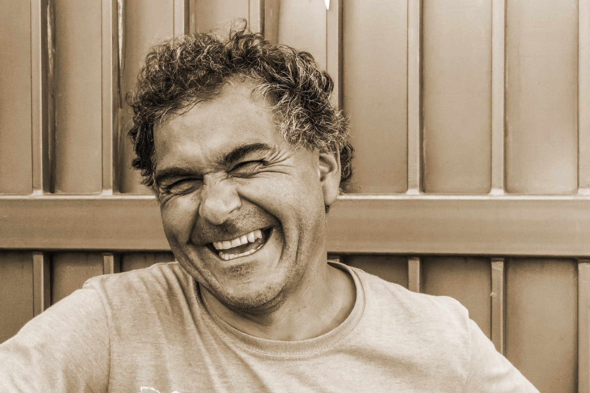 Older man with curly hair laughing