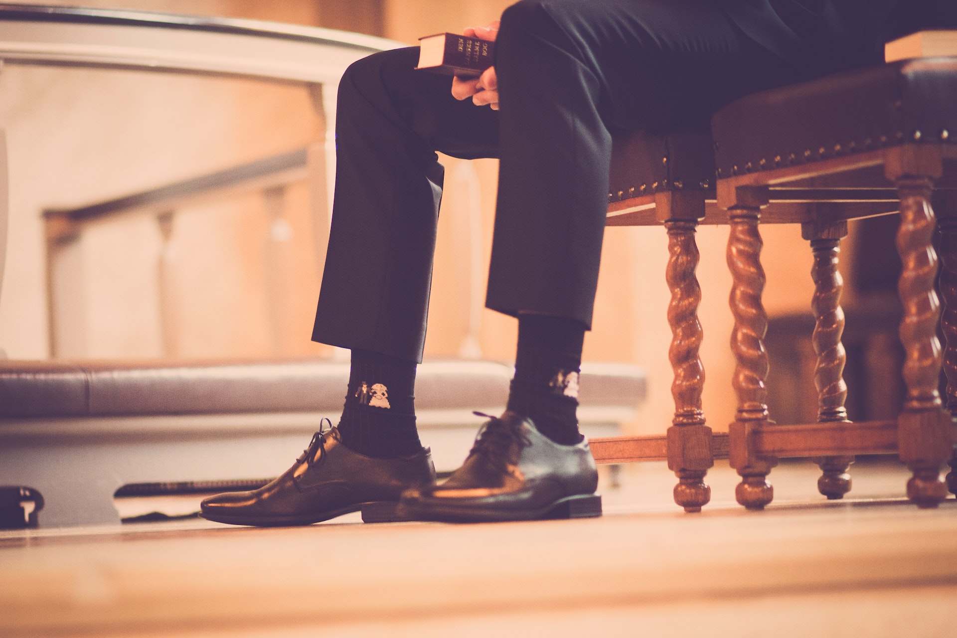 Man in suit sitting in a church holding a bible