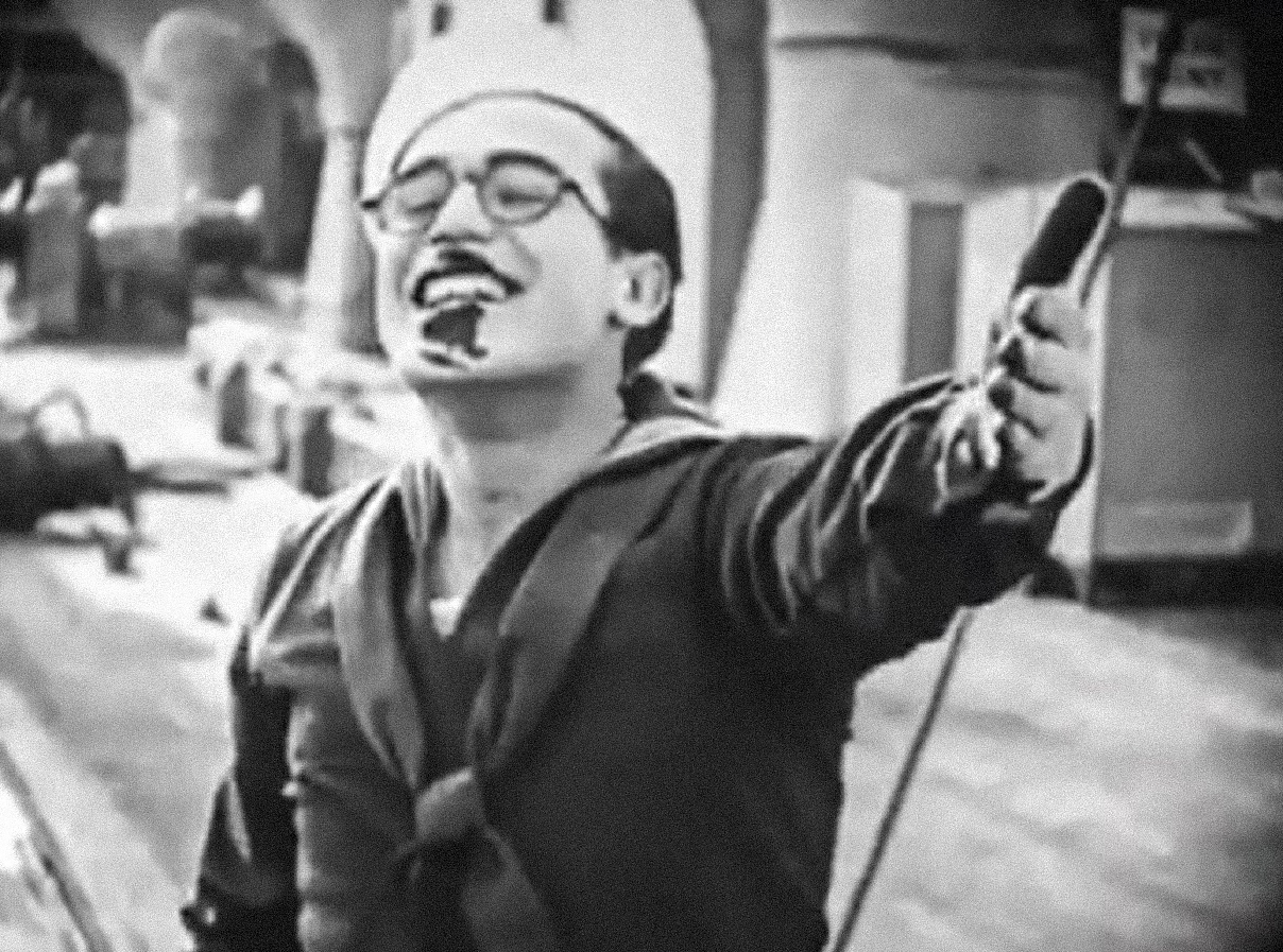 Screenshot B&W - Harold Lloyd wearing gloves and smiling  - from A Sailor-Made Man (1921)