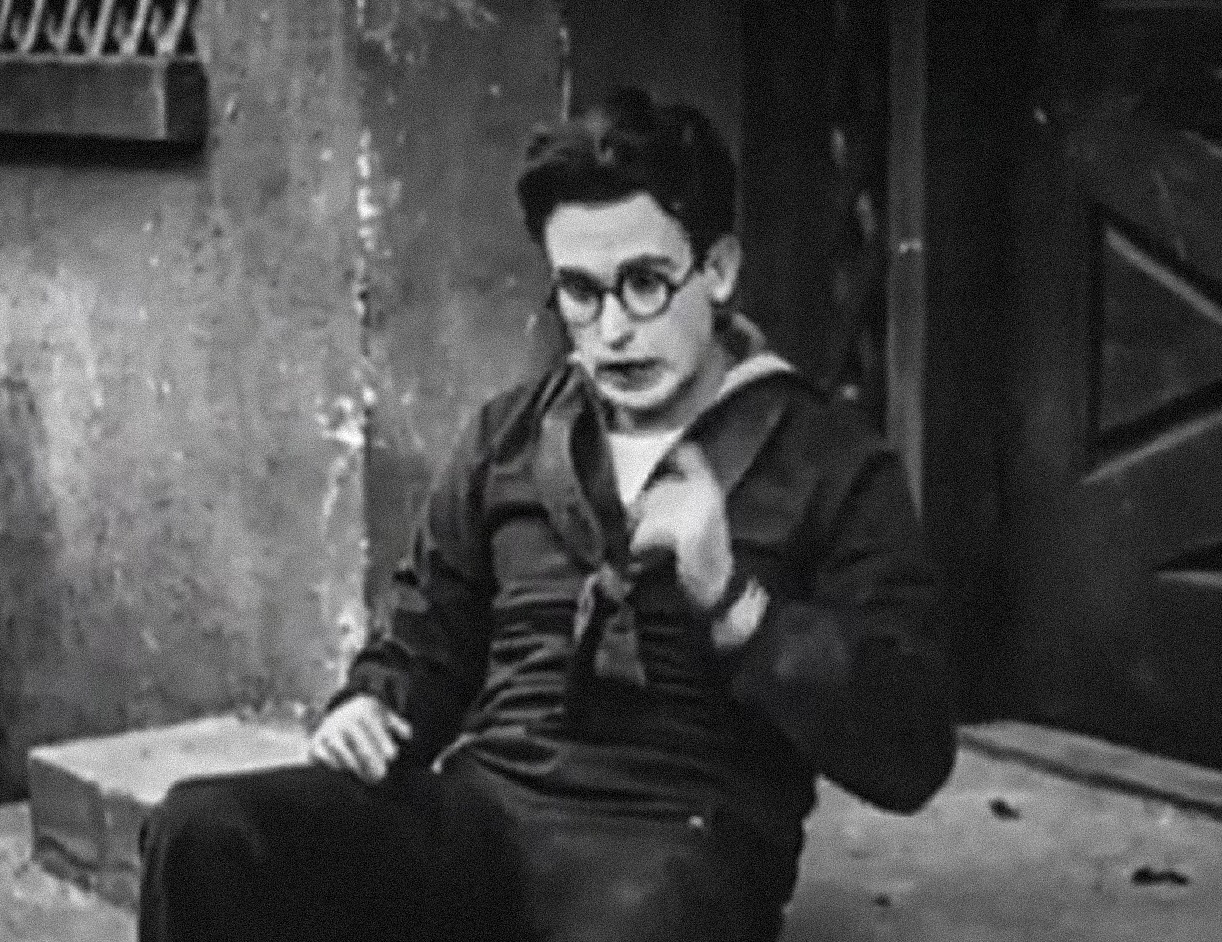 Screenshot B&W - Harold Lloyd wearing navy suit and seating on the ground - from A Sailor-Made Man (1921)