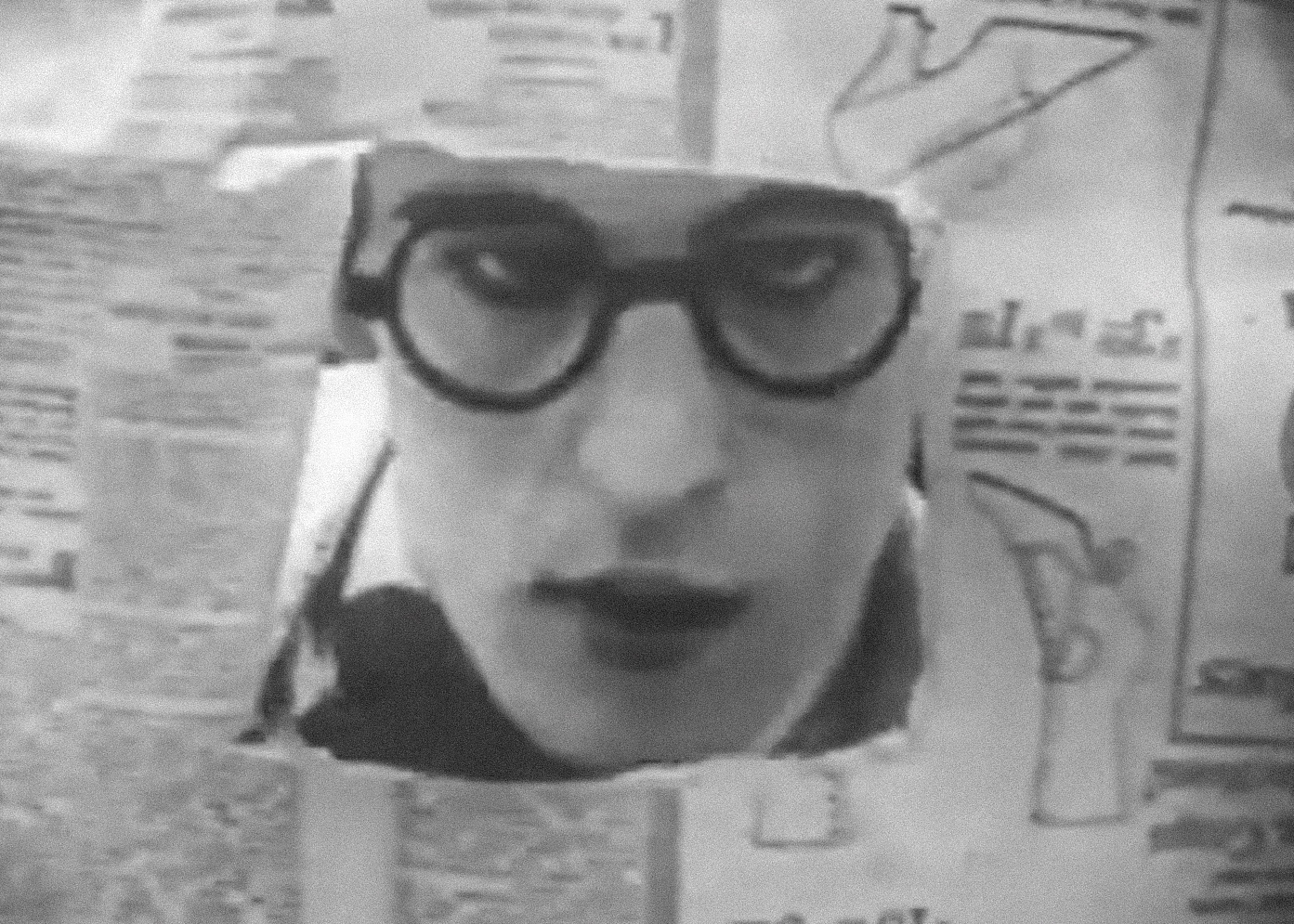 Screenshot B&W - Harold Lloyd wearing glasses and looking thru paper  - from The Flirt (1917)