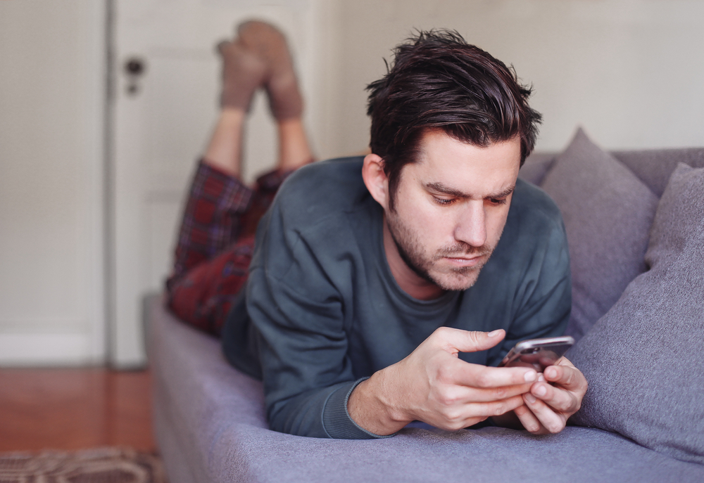 Young serious man looking at his mobile phone using a dating app