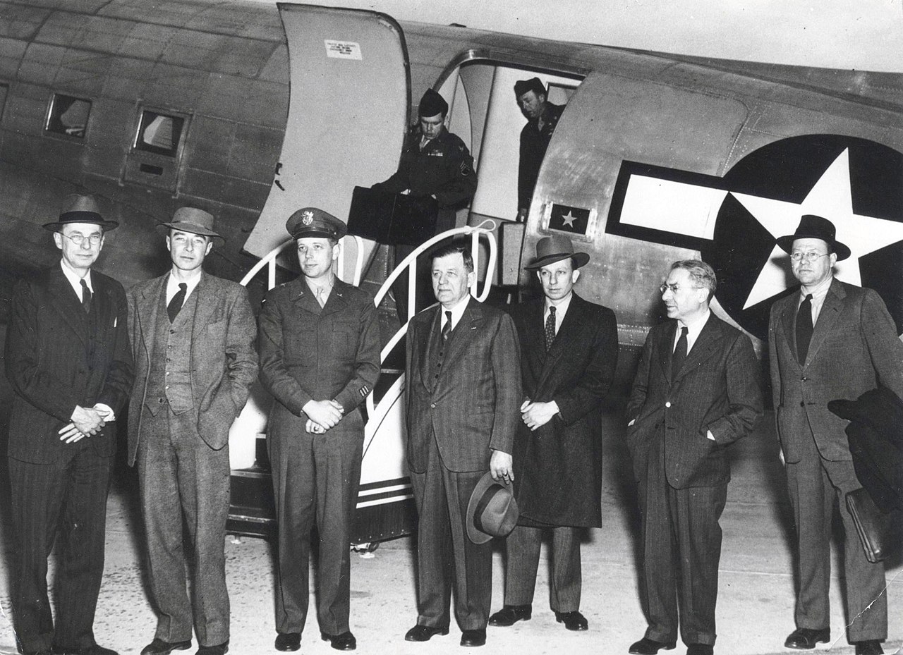 Robert Oppenheimer with colleagues in front of a plane