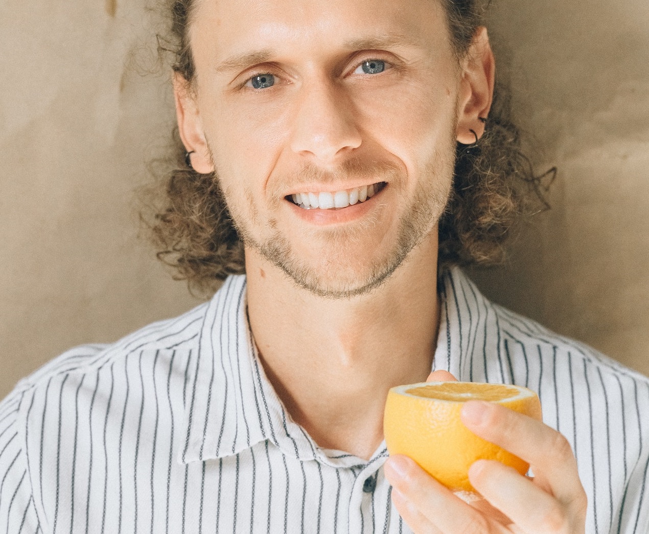 Man holding an orange in his hand.