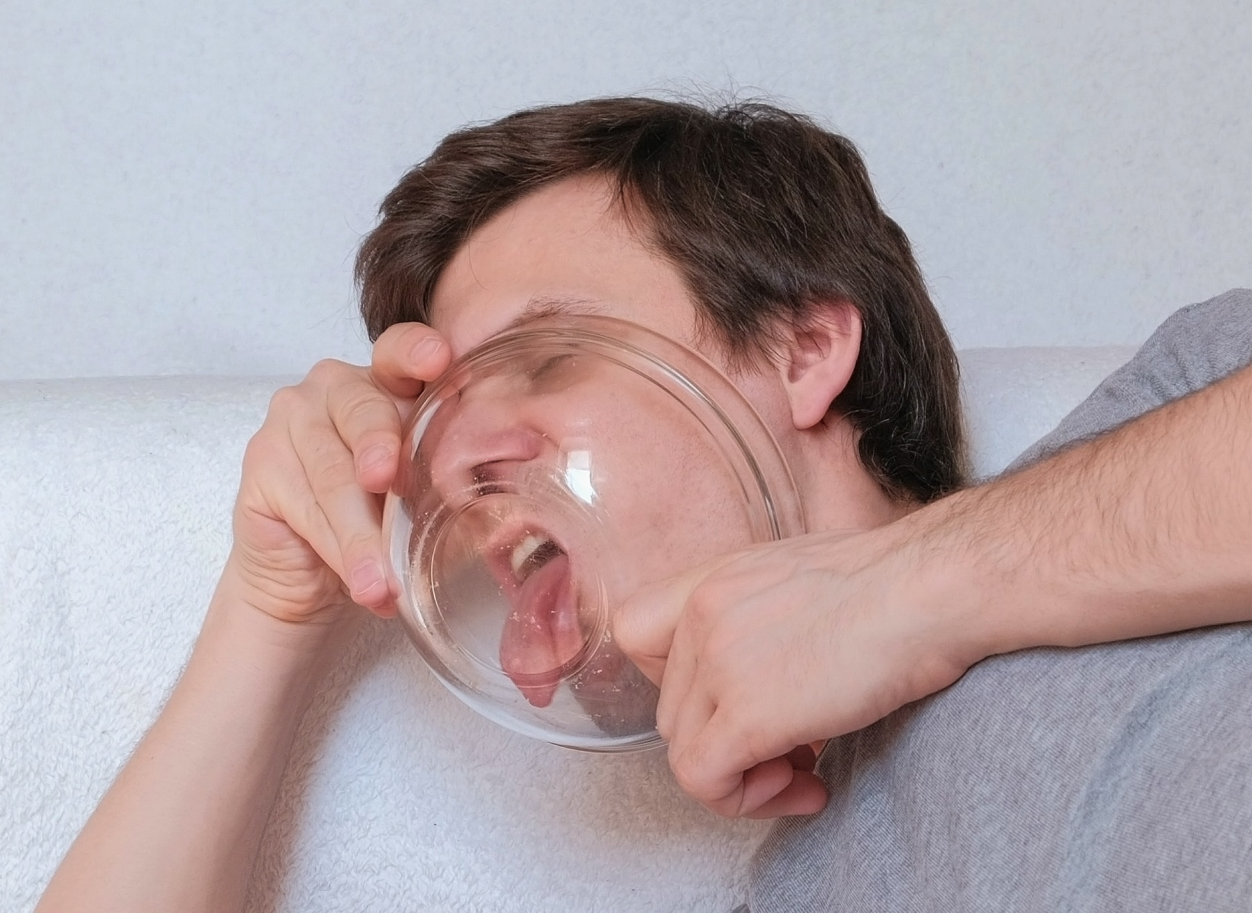 Handsome young man licking a plate of chips.