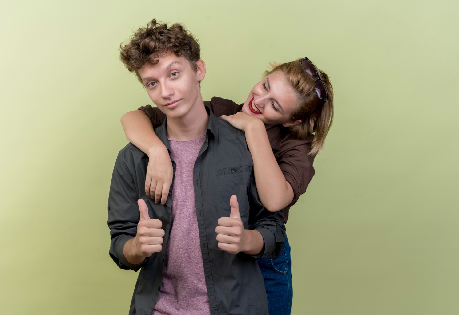 Young beautiful couple wearing casual clothes boy and girl happy in love on green background.