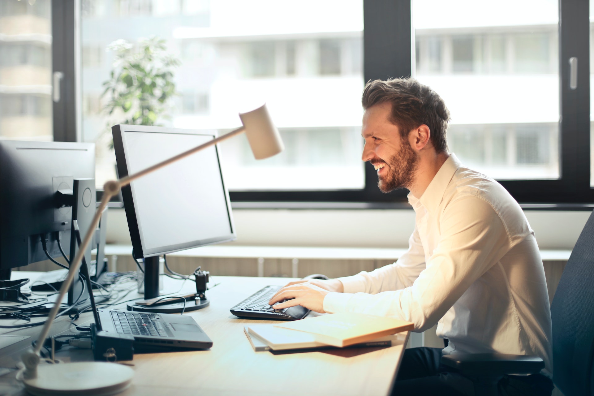 Man working on a computer at office smiling and happy