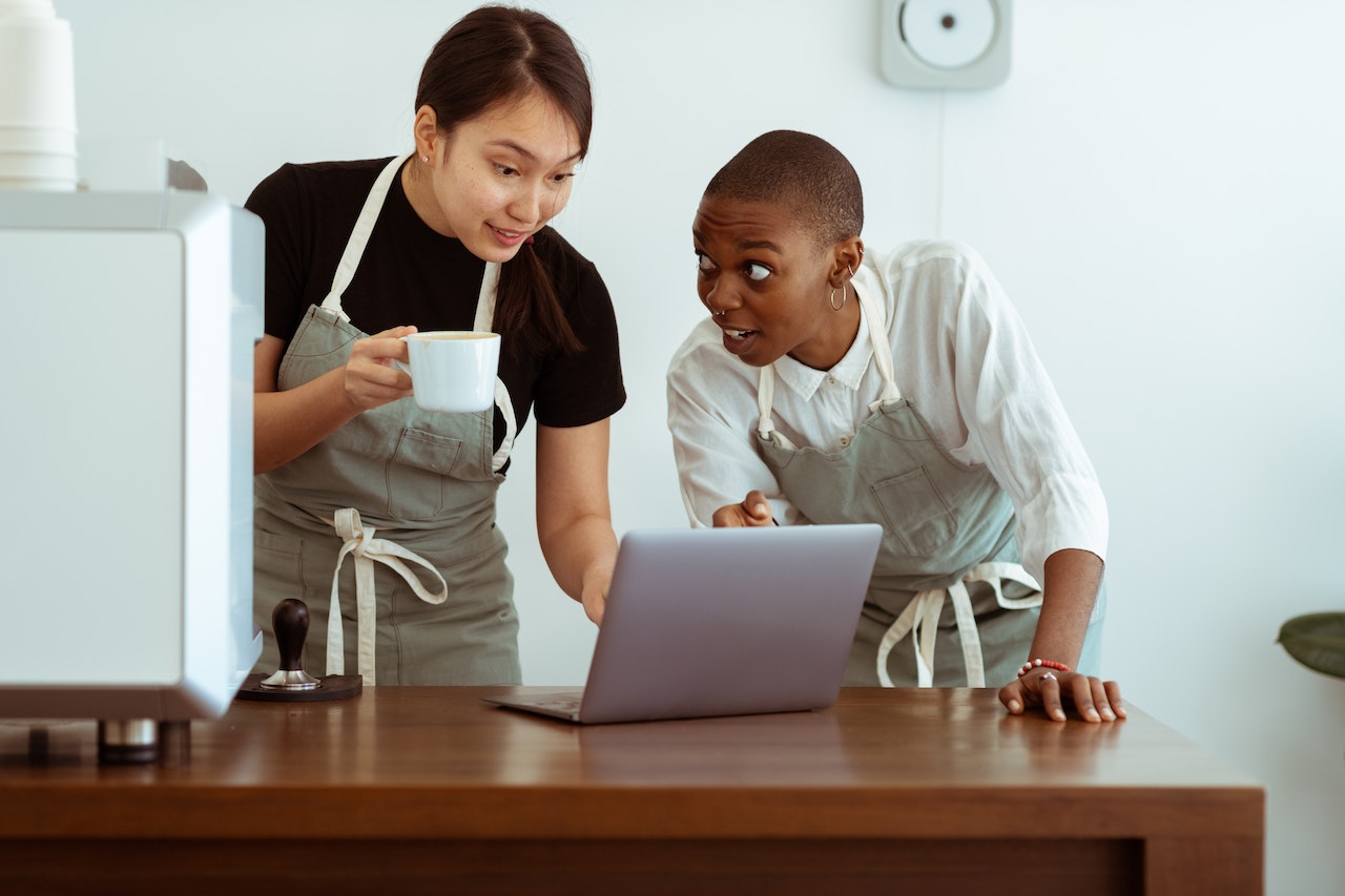 People working in restaurant kitchen are listening music.