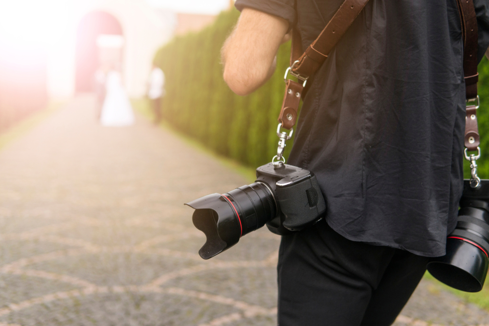 Professional wedding photographer takes pictures of the bride and groom in garden