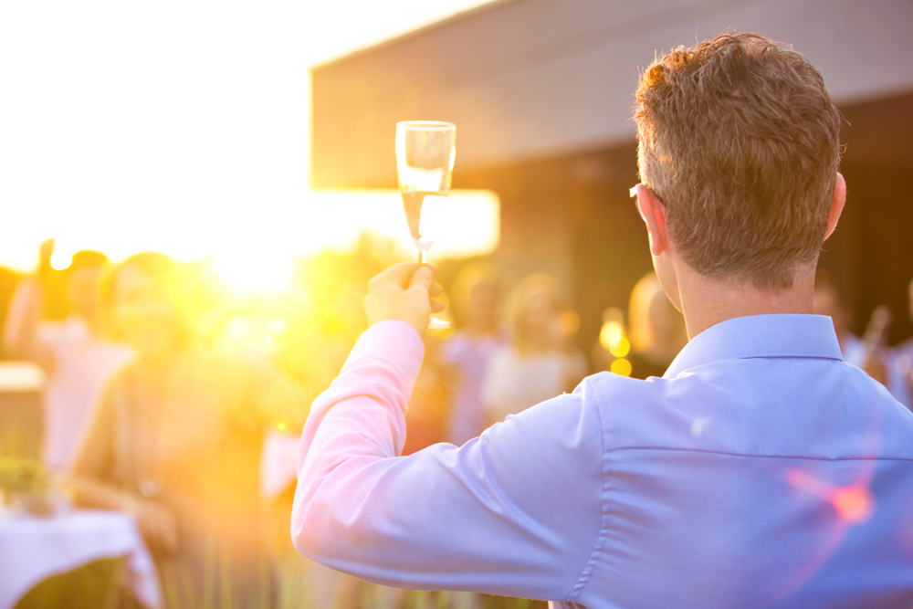 Best man giving a toast to bride and groom