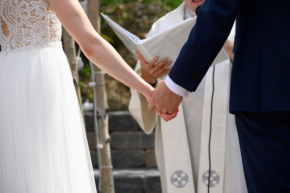 husband and wife holding hands at their wedding