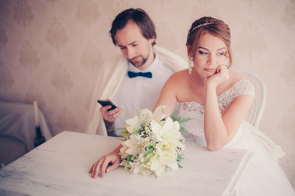 The bride is upset, the groom is distracted by the phone