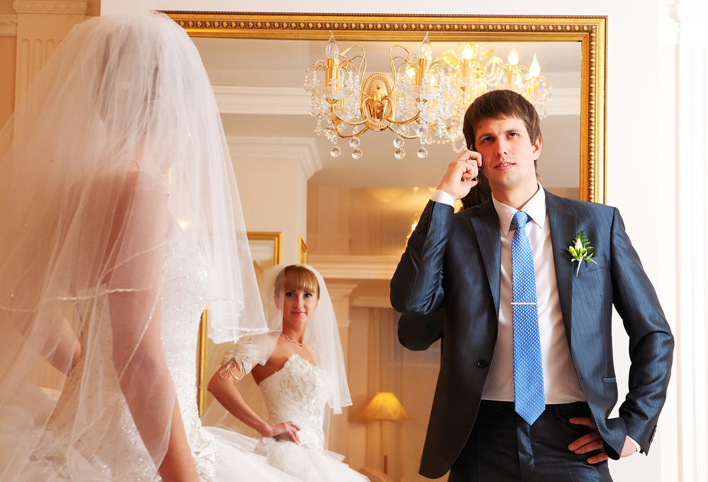 A groom and bride against a mirror.