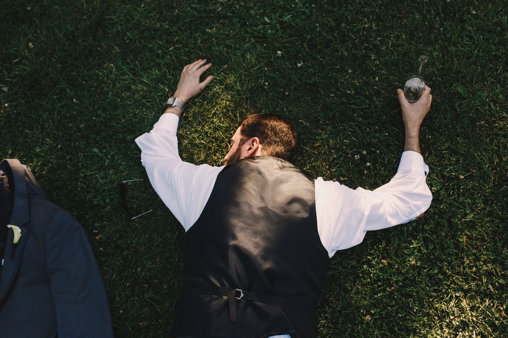 Drunk groom lying on the grass