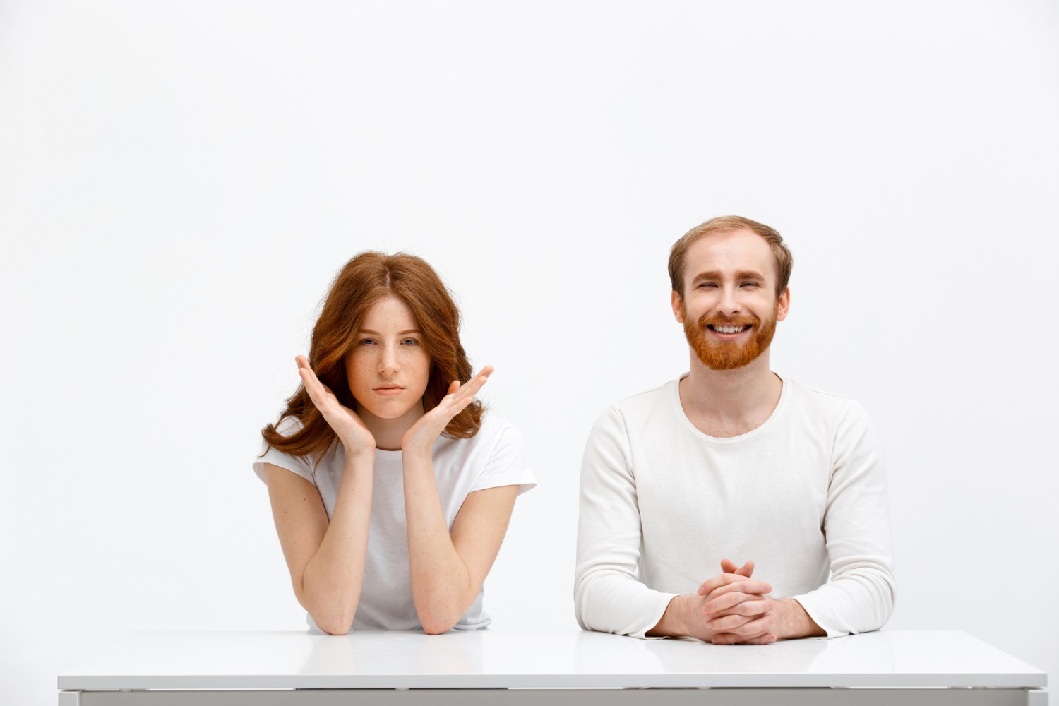 Woman with serious face seating next to a smiling man.