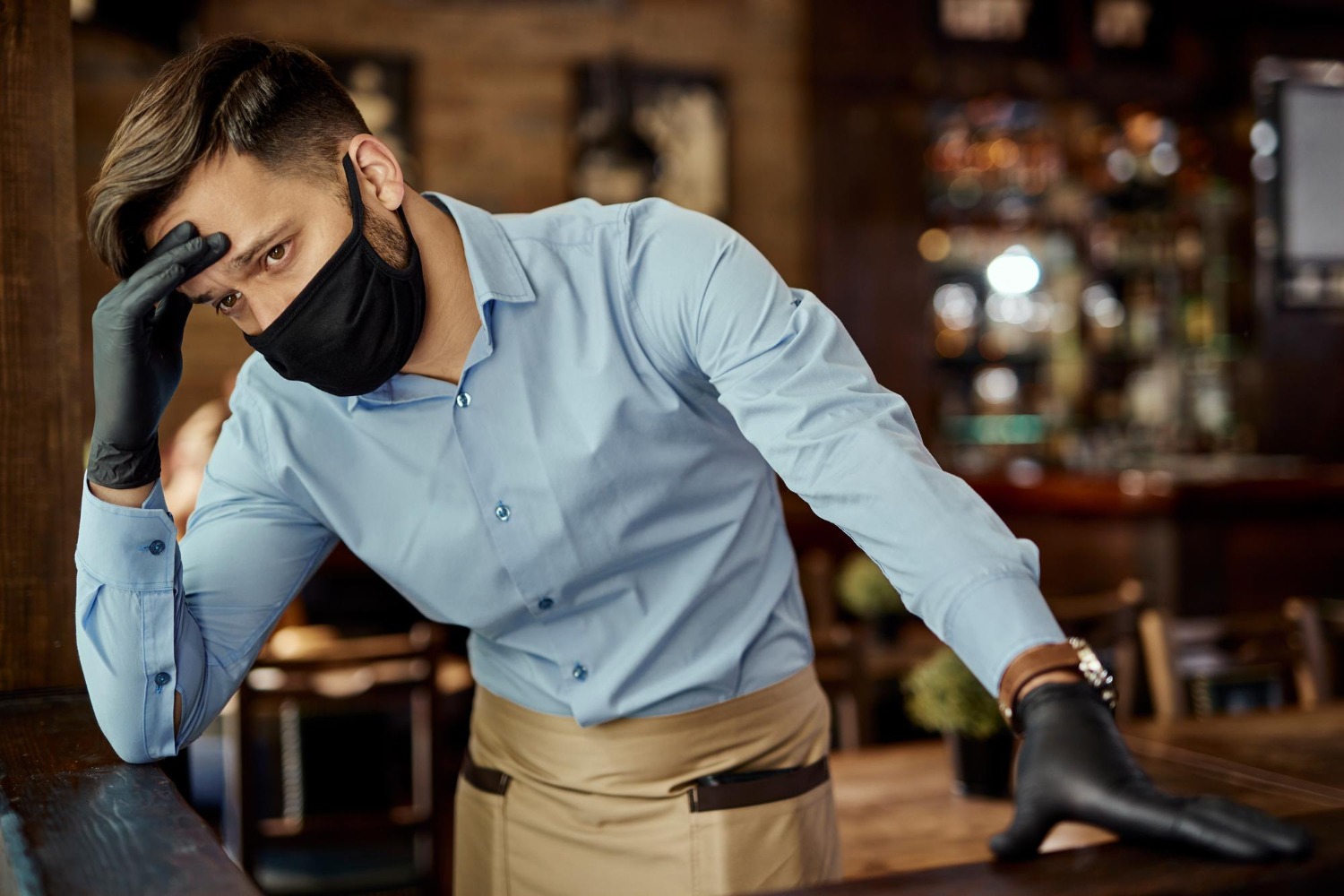 Distraught waiter holding his head.