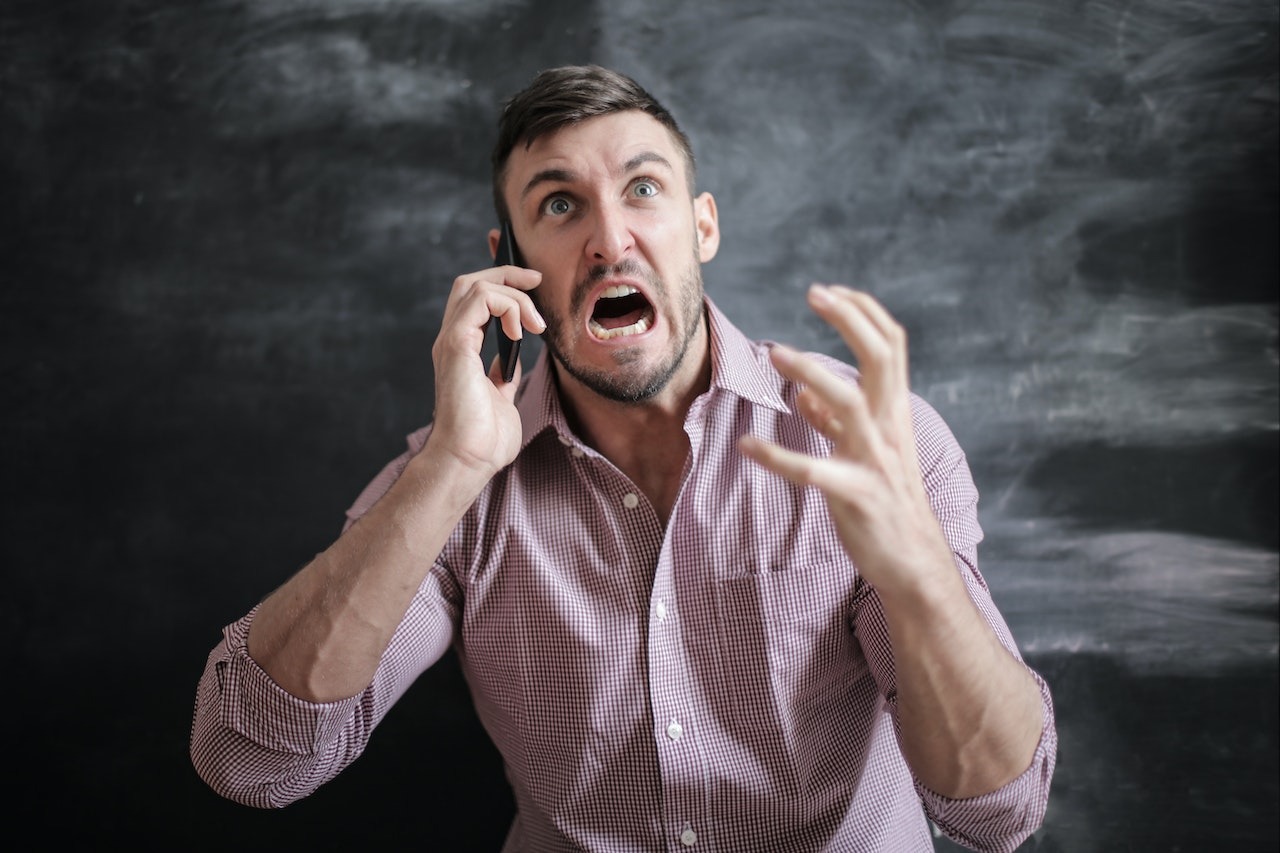Angry man screaming on the phone.
