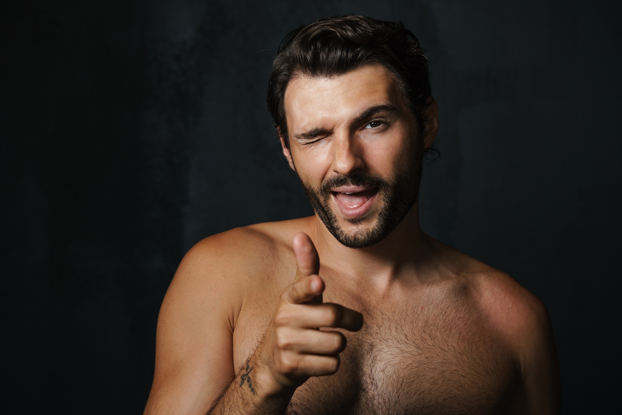 Half naked man winking and pointing.