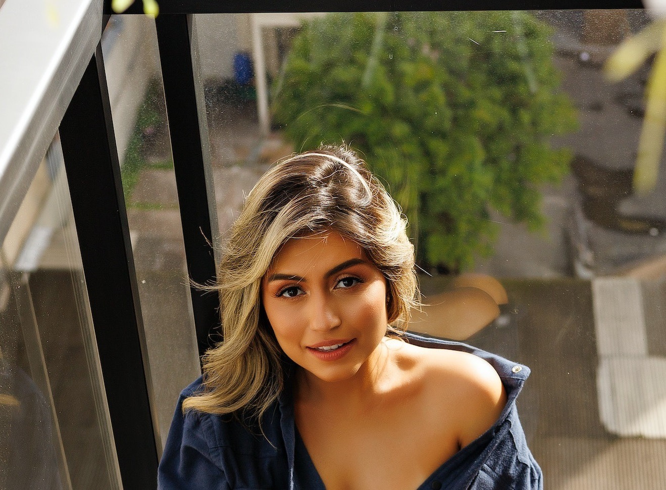 Smiling woman wearing open blue shirt.