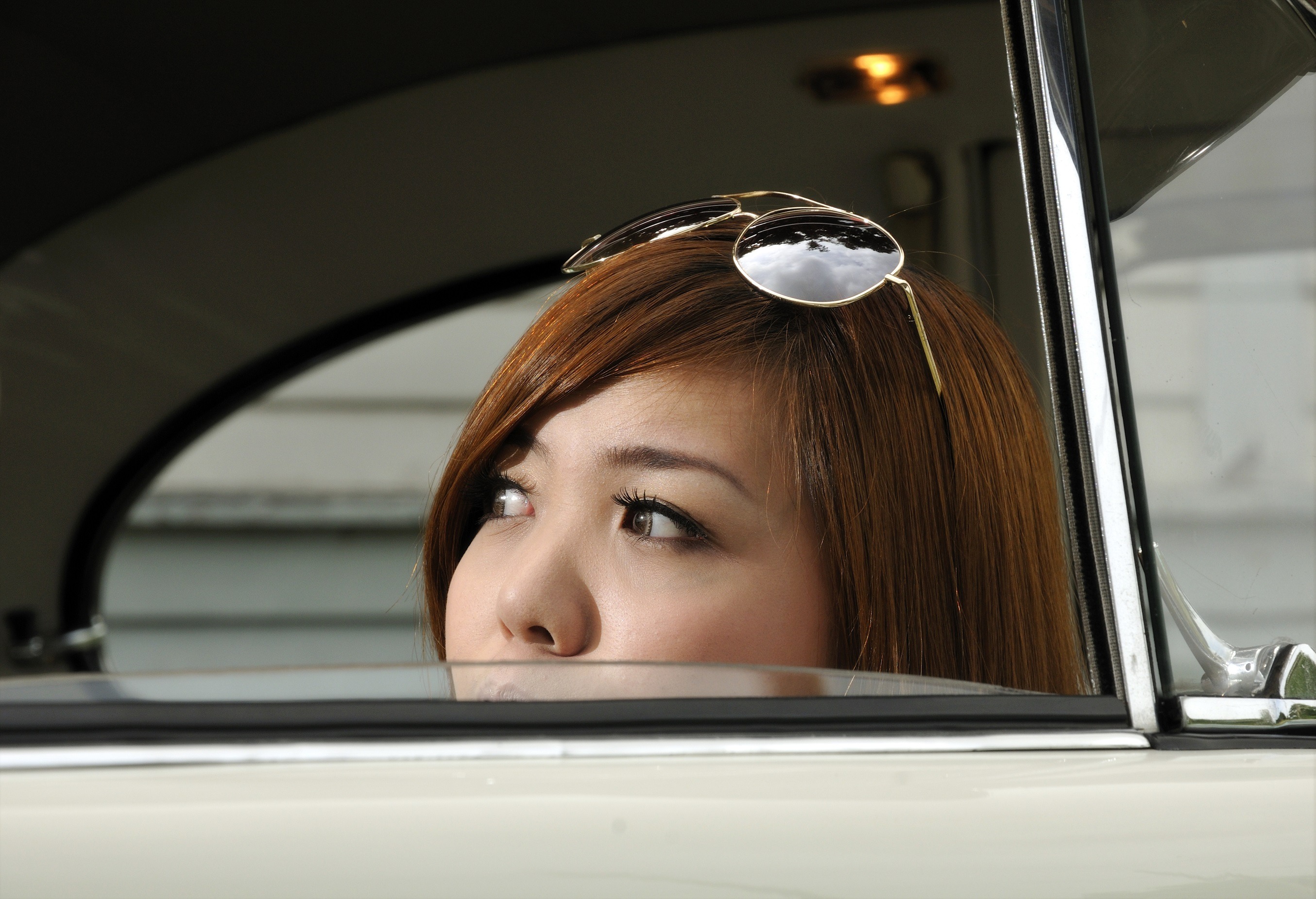 A girl hiding inside an antique car.
