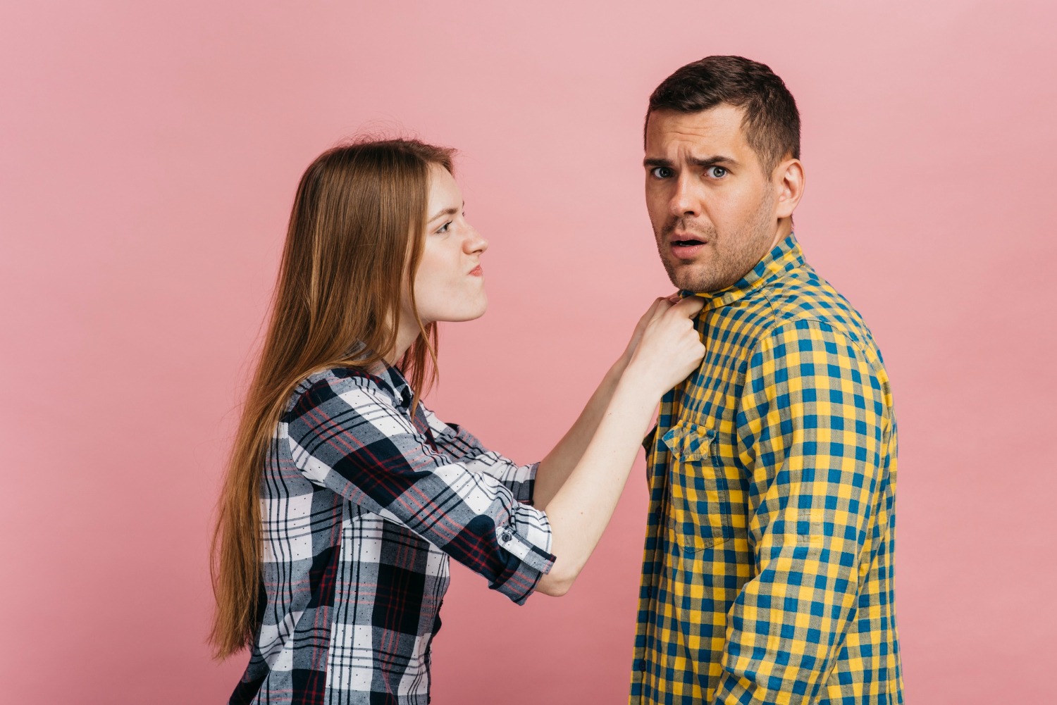 Young woman holding a man looking scared.