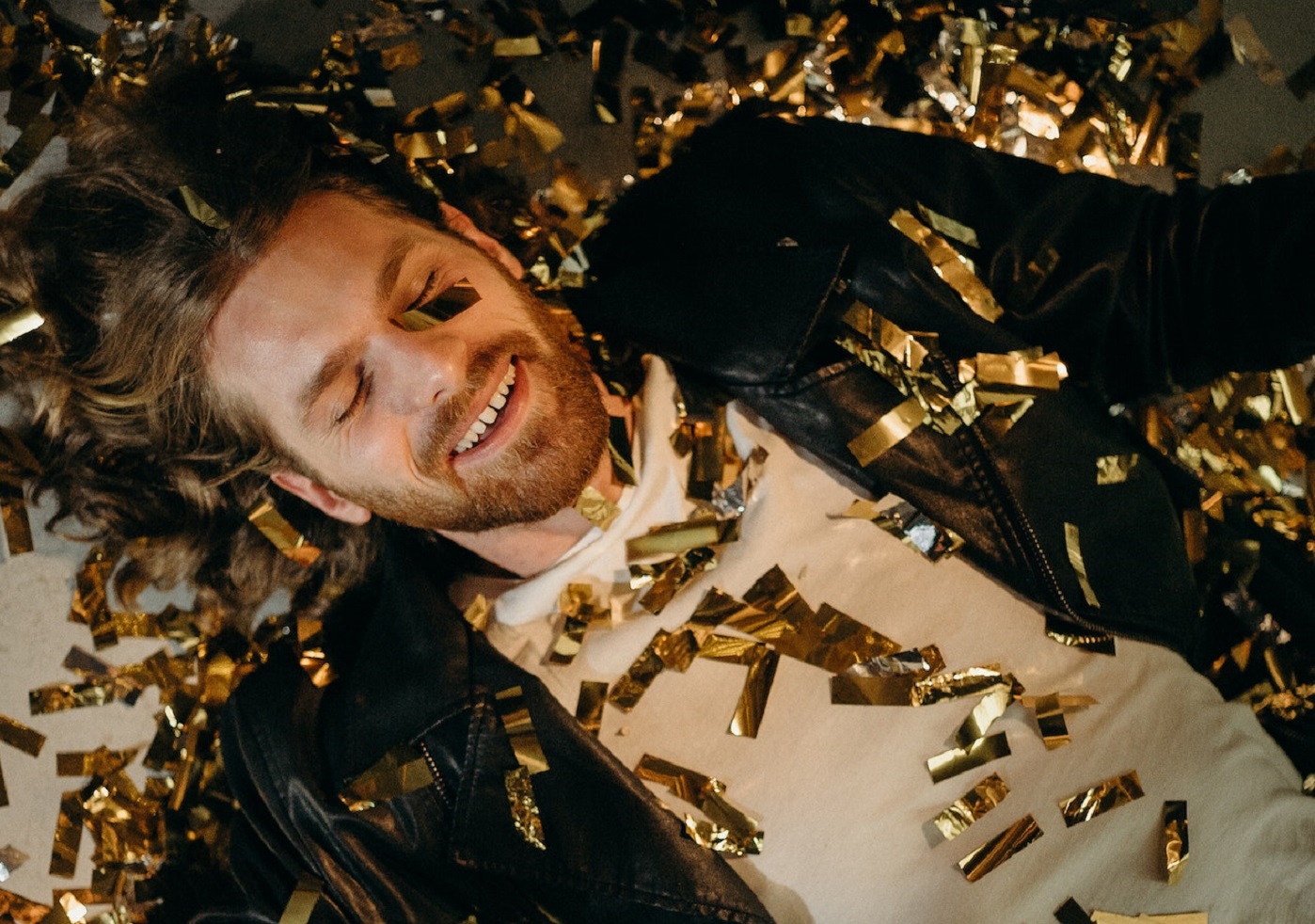 Man laying on the ground drunk.