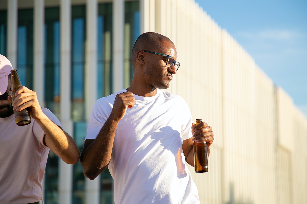 Men dancing and drinking beer on party.