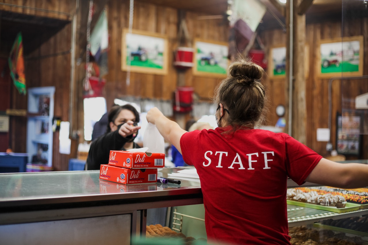 Fast food worker in red uniform takes the order.