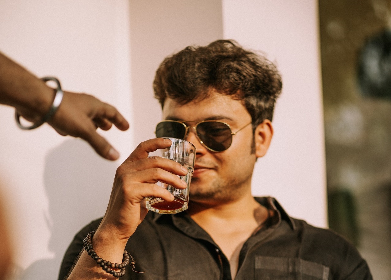 Drunk man wearing black shirt and glasses.