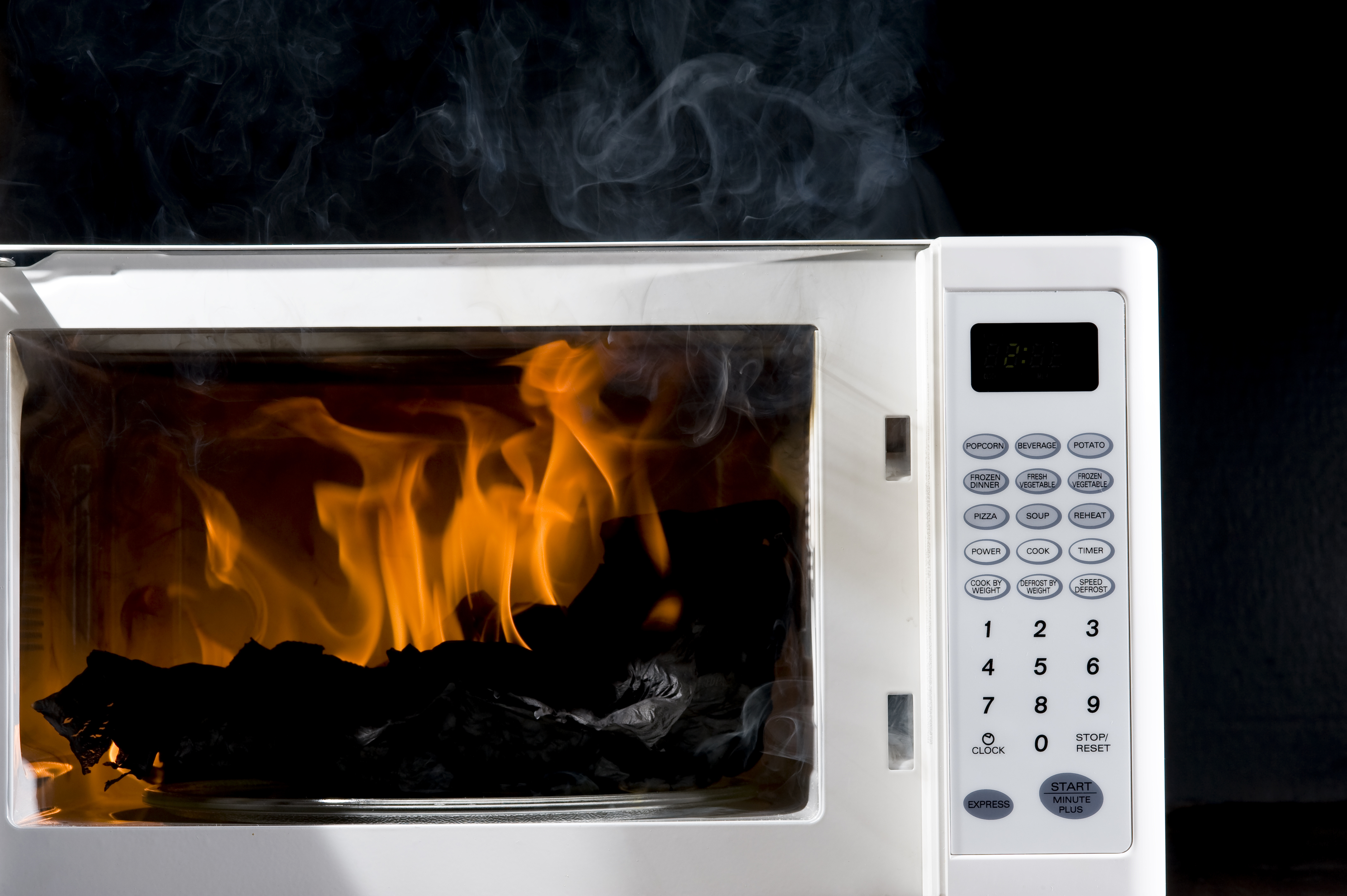 White microwave with burning food.
