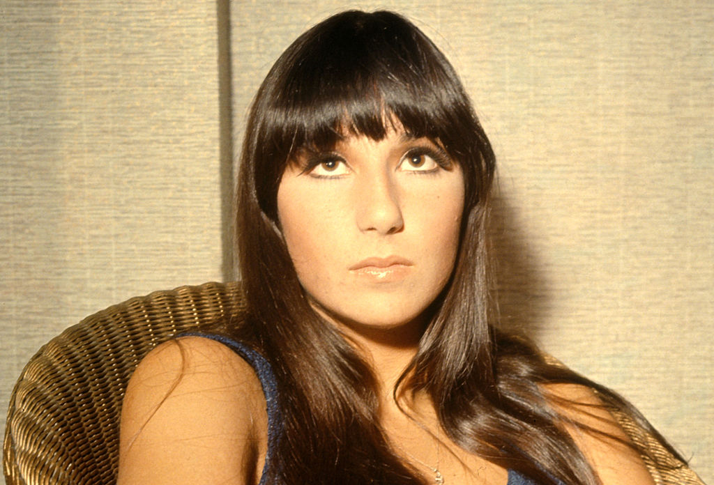 Cher photographed in 1965 sitting on a chair