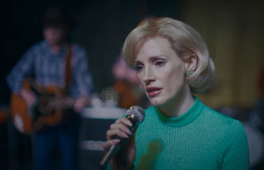 Jessica Chastain as Tammy Wynette singing on stage in green top