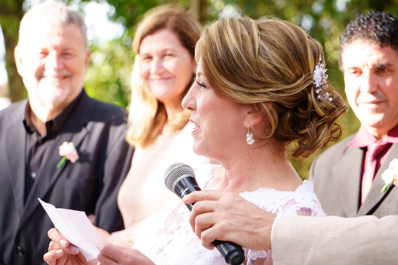 Woman holding a speech at wedding on a microphone.
