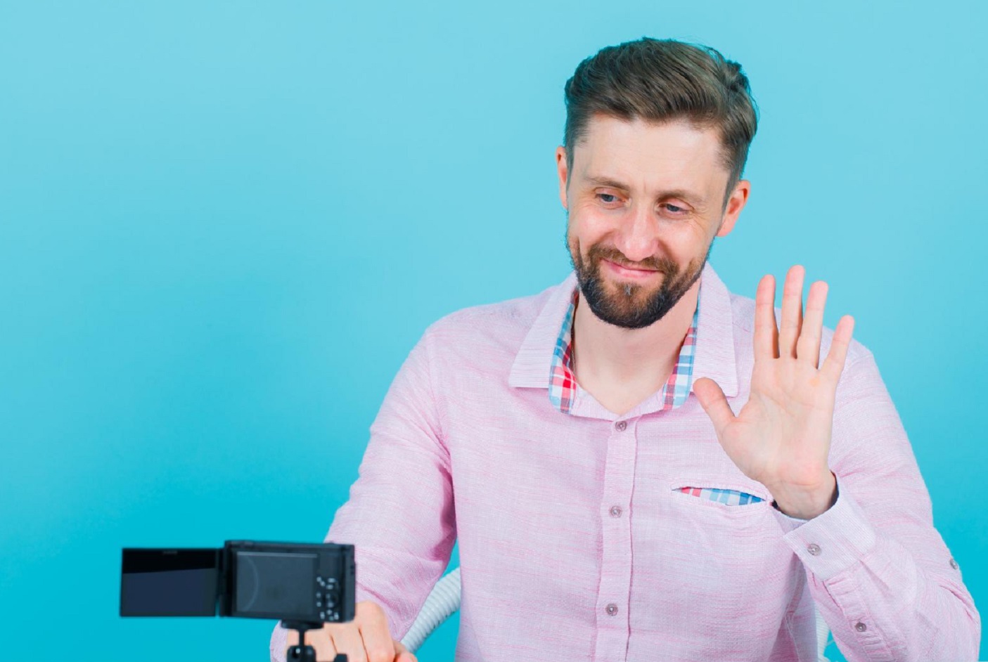 Man looking at waving at camera.