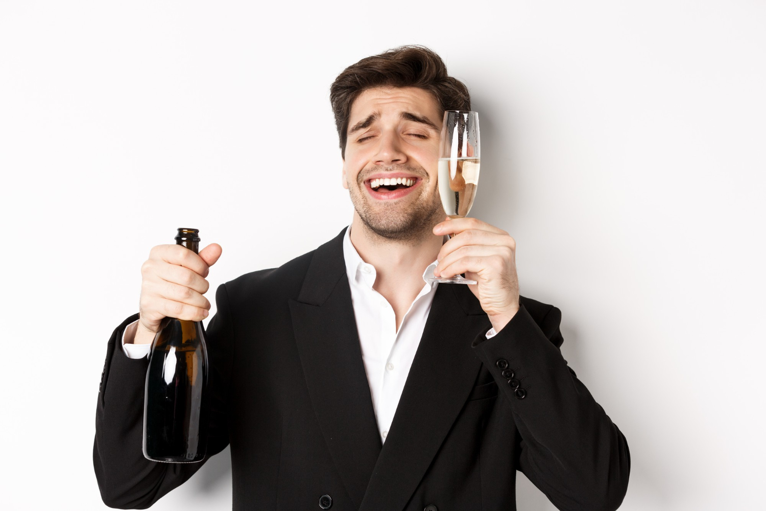Man looking drunk and holding a bottle and glass of wine.
