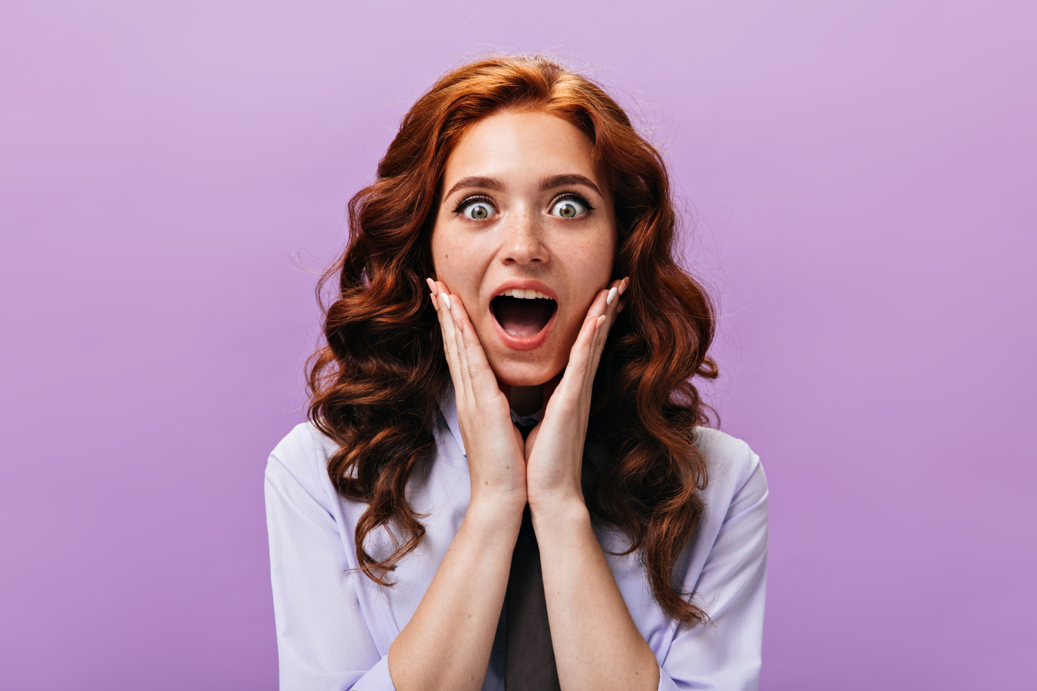 Woman is looking shocked, at purple background.
