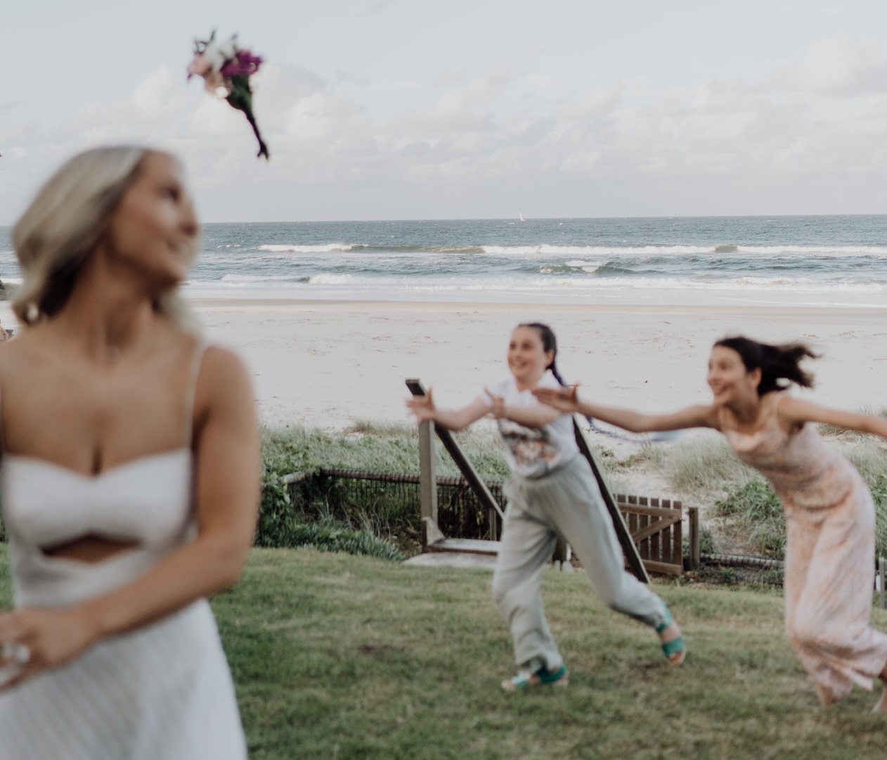 Two girls are running to catch bridal bouquet.