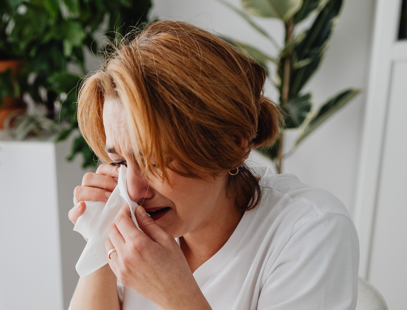 Woman is crying and holding a tissue.