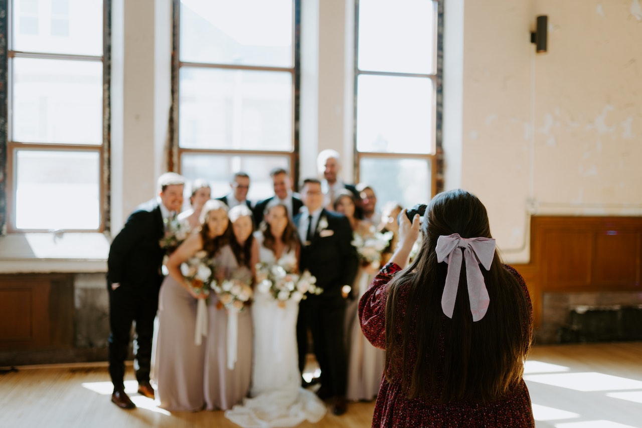 A woman is taking a photo at wedding reception.