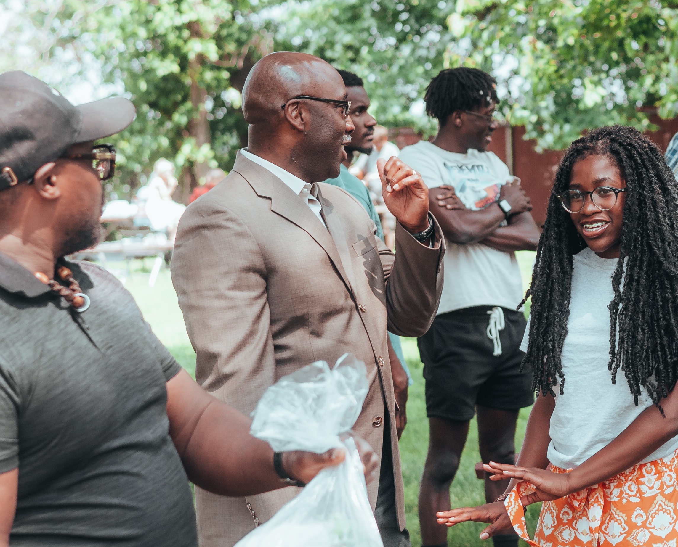 Young black girl is talking with a black man at party.