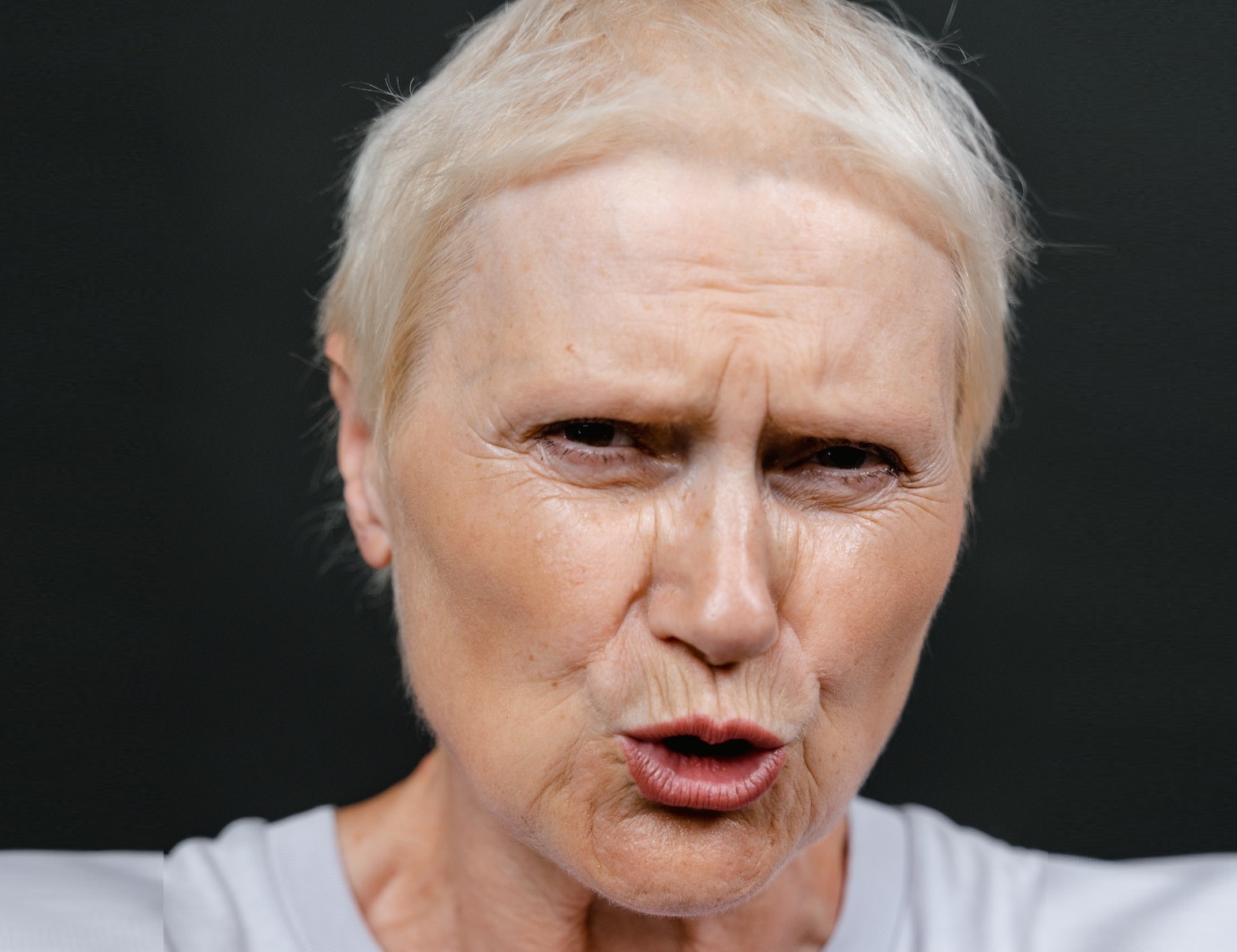 Woman is yelling and looking upset to camera.